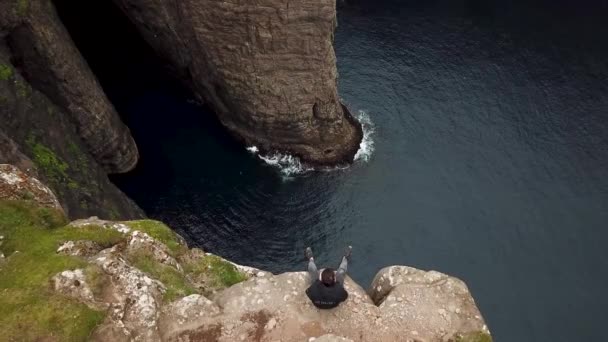 Vista Aérea Hombre Sentado Acantilado Esclavos Traelanipan Islas Feroe Lago — Vídeo de stock