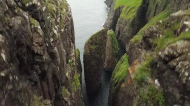 Faroe Adaları, Dunnesdrangar 'ın insansız hava aracı görüntüsü. İnanılmaz doğa, Faroe Adaları 'ndaki büyük kayalıklar ve dağlar. Vagar Adası. Bir sürü uçan deniz kuşu. Yazın güneşli bir gün. Yüksek kalite 4k görüntü. 