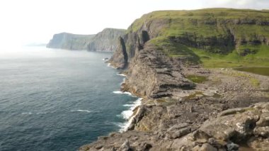 Aerial view of huge cliffs near Slave cliff or Traelanipan and Sorvagsvatn lake or Leitisvatn in Faroe Islands. Amazing nature. Huge cliffs. Lake above the ocean. Bosdalafossur waterfall. 4k footage.