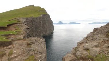 Kayadaki bir boşluk. Faroe Adaları 'ndaki en büyük göl olan Sorvagsvatn Gölü veya Leitisvatn yakınlarında büyük bir dağ veya kaya oluşumu. Yüksek kalite 4K görüntü. İnanılmaz bir doğa. Okyanusun üzerindeki göl.