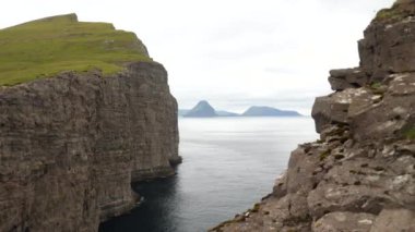 Kayadaki bir boşluk. Faroe Adaları 'ndaki en büyük göl olan Sorvagsvatn Gölü veya Leitisvatn yakınlarında büyük bir dağ veya kaya oluşumu. Yüksek kalite 4K görüntü. İnanılmaz bir doğa. Okyanusun üzerindeki göl.