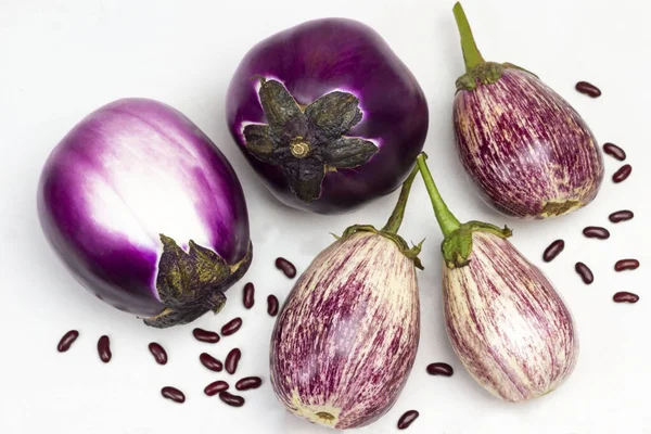 テーブルの上に紫と縞模様のナス 豆の種 平置きだ — ストック写真