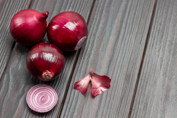 Drie Paarse Uienkoppen Schillen Tafel Donker Houten Achtergrond Bovenaanzicht Kopieerruimte — Stockfoto