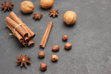 Bir demet tarçın çubuğu, yıldız anason ve fındık. Uzayı kopyala Siyah arka plan. Üst görünüm