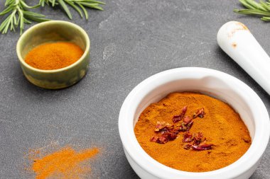 Havan ve kasede kırmızı biber. Pistil ve biberiye. Siyah arka plan. Üst görünüm