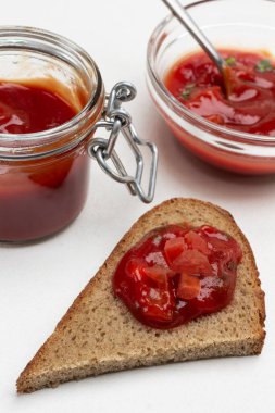 Bir dilim ekmeğe domates sosu. Kavanozda ve kasede sos. Kapatın. Beyaz arkaplan