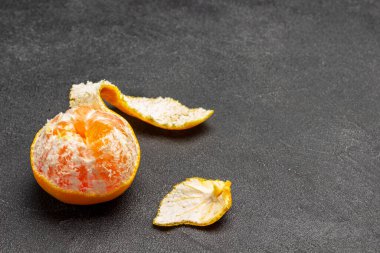 Mandalina ve kabuğu kes. Siyah arka plan. Üst Manzara. Boşluğu kopyala