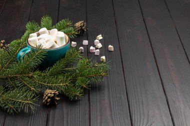 Seramik bardakta şekerlemeler. Çam dalları ve koniler. Uzayı kopyala Koyu tahta arkaplan.