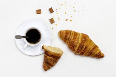 Bir fincan kahve ve esmer şeker. Ay çörekleri masada. Düz yatıyordu. Beyaz arkaplan.