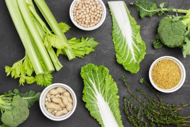 Mısır gevreği, fındık ve sebzeler siyah arka planda. Düz yatıyordu