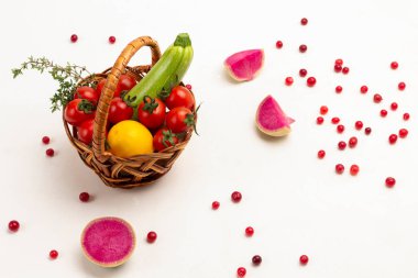 Sepette kırmızı domates ve kabak. Masada pembe turp parçaları var. Üst Manzara. Beyaz arkaplan