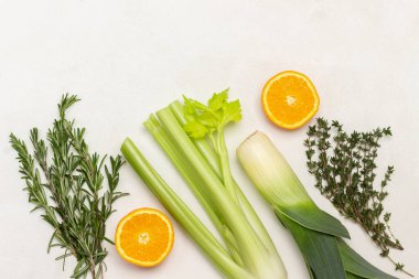 Biberiye, kekik, pırasa, kereviz sapı ve turuncu yarımlar. Uzayı kopyala Düz yatıyordu. Beyaz arkaplan