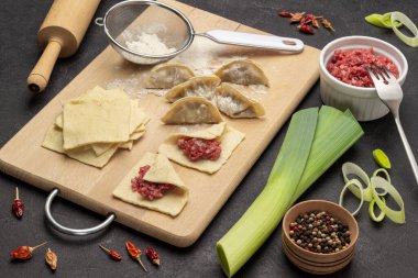 Çiğ gyoza köftesi ve hamur parçaları. Kasede et, baharat ve pırasa var. Üst Manzara. Siyah arkaplan