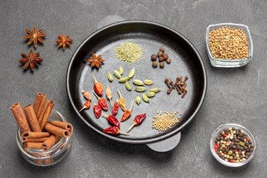 Tarçın çubukları, kırmızı biber kabukları, yıldız anasonu ve kızartma tavasında karanfil. Düz yatıyordu. Siyah arkaplan