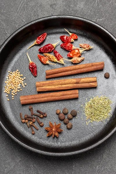 Tarçın çubukları, kırmızı biber kabukları, yıldız anasonu ve kızartma tavasında karanfil. Düz yatıyordu. Siyah arkaplan