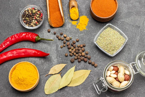 Cam kavanozda fındıklar. Zemin zerdeçal ve biber kâse ve kepçe. Allspice ve defne yaprağı. Taze kırmızı biber. Düz yatıyordu. Siyah arkaplan