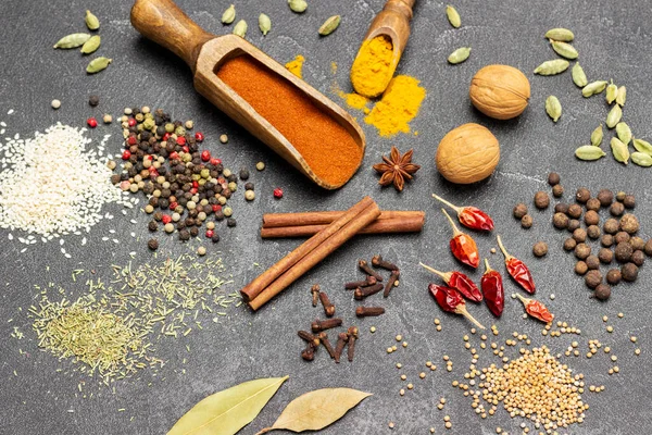 Masada bir çift kuru baharat var. Ahşap kepçe içinde kırmızı biber. Üst Manzara. Siyah arkaplan