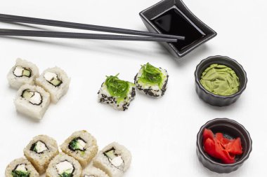 Suşi seti, sos, wasabi ve siyah kaselerde pembe zencefil. Üst Manzara. Beyaz arkaplan