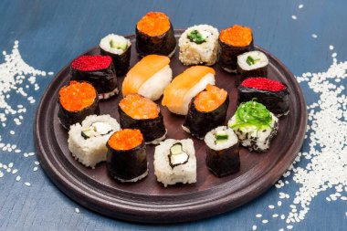 Suşi tahtayı kesiyor. Masada pilav var. Üst Manzara. Mavi arkaplan. 