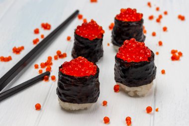 Havyarlı ve çubuklu suşi. Havyar masaya kondu. Üst Manzara. Beyaz arkaplan.