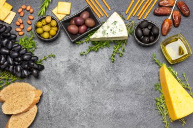 Zeytin ve peynirli aperatif için aperatif, üzüm ve hurma, baget ve kraker, fındık ve kekik. Uzayı kopyala Düz yatıyordu. Siyah arkaplan.