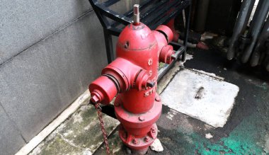 Bir binanın önündeki kırmızı yangın musluğunun fotoğrafı, bu aletin işlevi itfaiyeciler tarafından söndürüldüğünde bir su kaynağı olarak kullanılır.