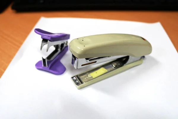 A white paperclip or stapler is on the office desk, this tool is part of office or stationary supplies and equipment