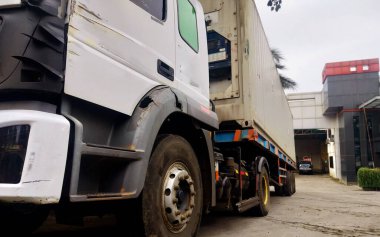 Uzun, tekerlekli bir konteynır kamyonu, bu kamyon limandan mal taşımak için çok güçlüdür.