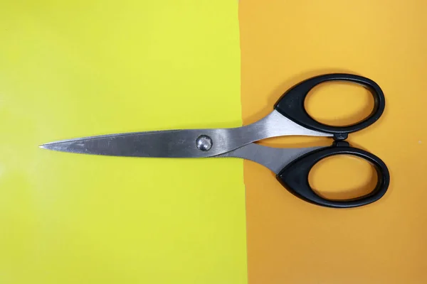 Photo of scissors on color paper, this tool is used to cut something