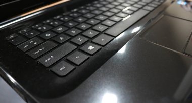 Ofis masasındaki siyah bir dizüstü bilgisayarın fotoğrafı.