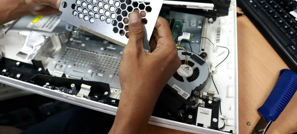 Photo of the activity of repairing electronic equipment, repairman repairing a broken computer