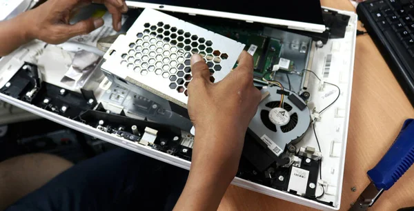 Photo of the activity of repairing electronic equipment, repairman repairing a broken computer
