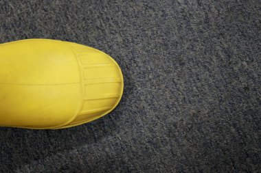 Su geçirmez sarı lastik botlar genellikle inşaat işçileri tarafından ayaklarının sert nesnelerden, kimyasallardan, zehirli sıvılardan, sellerden ve diğer kazalardan korunması için giyilir.