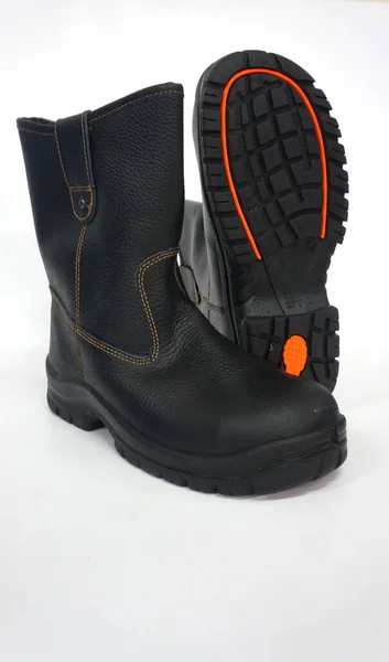 毎日の活動のためのクールな黒いハイブーツと足を保護します 作業者は足を事故から守るために足を保護するためにこれらの靴を着用します — ストック写真