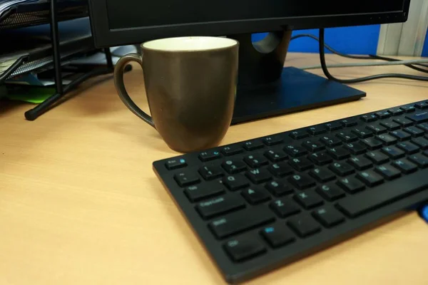 オフィスのコンピュータのキーボードの近くに完成したチョコレートのカップ — ストック写真