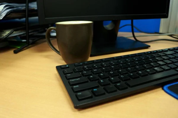 オフィスのコンピュータのキーボードの近くに完成したチョコレートのカップ — ストック写真