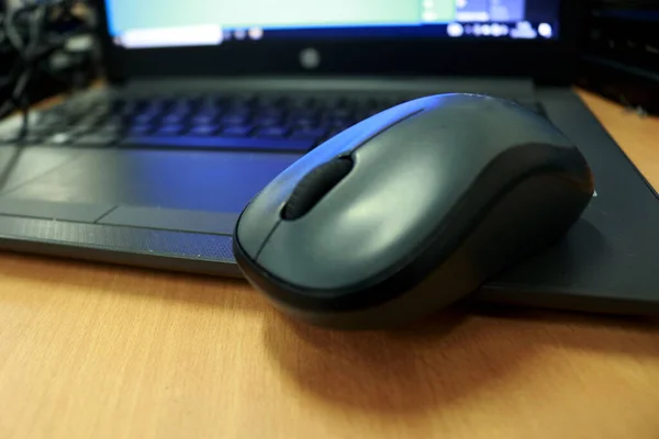 オフィスの机の上のマウスとラップトップ マウスとラップトップはコンピュータのハードウェア部分です — ストック写真