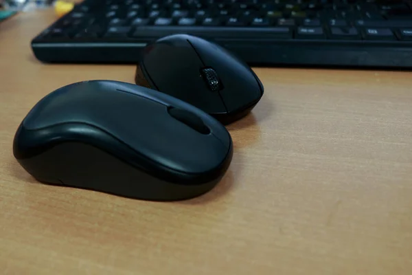 Two black computer mouse and keyboard photos on office desk