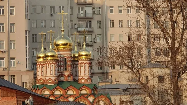 Moskova 'daki bir apartmanın arka planındaki Ortodoks kilisesinin kubbeleri.