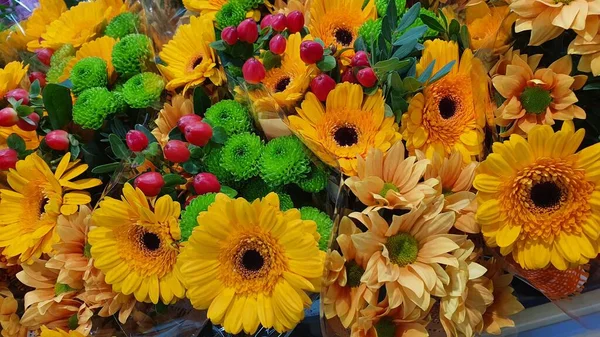Parlak bir buket gerbera ve turuncu renkli diğer çiçekler.