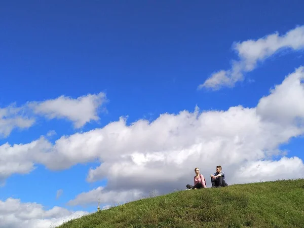 Çift tepede oturuyor, gökyüzüne karşı.. 