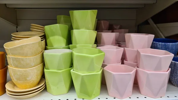 Raftaki farklı renkte bitkiler için saksılar. 