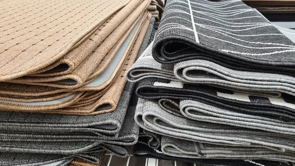 Farklı renkte ve yapılarda yığılmış halılar. 