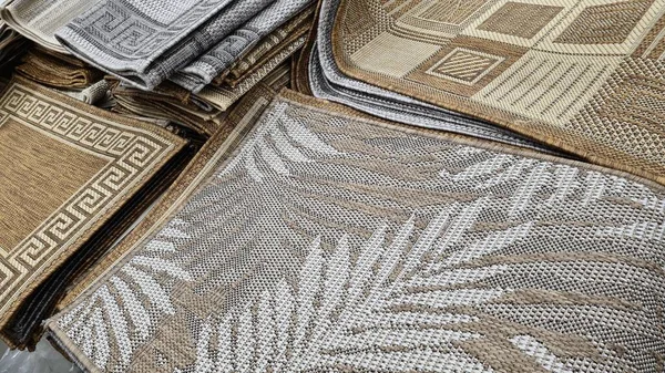 Farklı renkte ve yapılarda yığılmış halılar. 