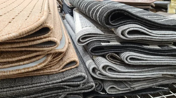 Farklı renkte ve yapılarda yığılmış halılar. 