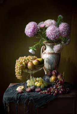 Paskalya çiçekleri ve cam vazoda meyvelerle dolu bir hayat.