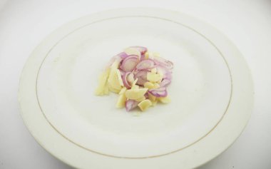 Beyaz arka planı olan bir tabakta dilimlenmiş soğan ve sarımsak.