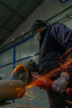 Beyaz adam makine atölyesinde radyal testere kullanıyor.