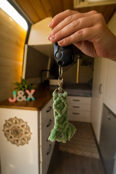 interior of a camper van with a woman\'s hand holding a key