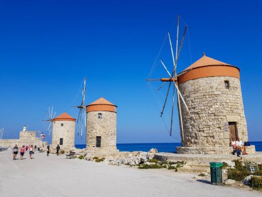 Deniz kenarındaki renkli yel değirmenleri. Mavi gökyüzü. Yaz güneşli bir gün. eski şehir Rodos, Yunanistan 'ı gezmek, 30,10.2019 turizm ve dinlenme kavramı
